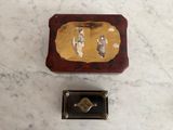 a small box with a painting on it next to a small box with a key