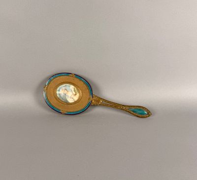une cuillère en or au manche bleu posée sur une surface blanche