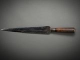 a close up of a knife with a wooden handle on a table