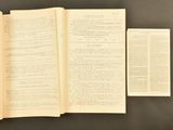 an open book sitting on top of a table next to a piece of paper
