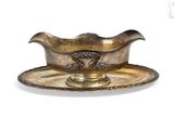 an antique silver plate with a bowl and saucer on it