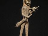 a bronze statue of a man holding a spear