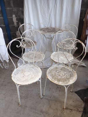 trois chaises blanches et une table dans une pièce avec un rideau blanc