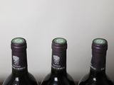 three bottles of wine are lined up on a table