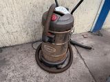 a vacuum that is sitting on the sidewalk next to a wall