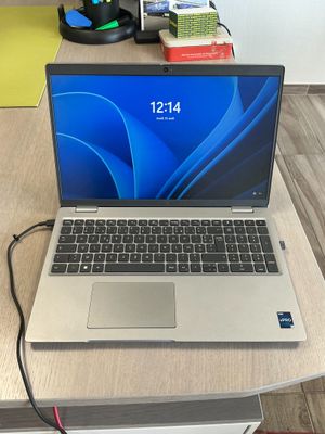 a laptop that is sitting on a desk with a charger on top of it