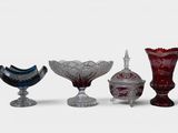 several different colored glass vases are lined up on a white surface