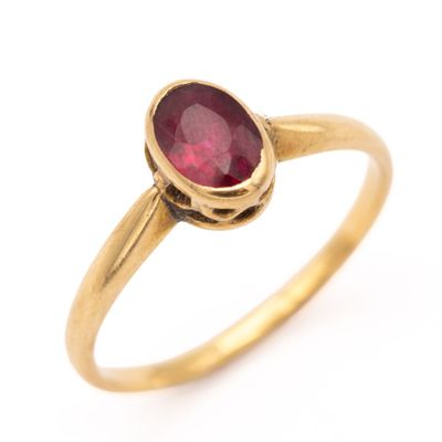 gros plan d'une bague en or avec une pierre en rubis