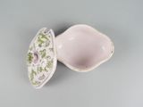 underside view of a porcelain container with a lid and a flower design