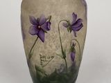 a vase with purple flowers painted on it on a white surface