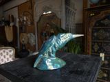 a blue dolphin statue on a black table in a living room