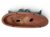 a clay sculpture of a fish in a bowl on the wall