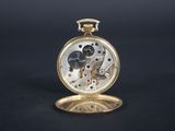 an antique pocket watch with a gold case and a black face