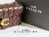 a brown purse sitting next to a black box