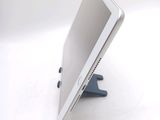 a tablet computer sitting on a stand on a white surface