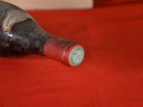 a bottle of wine sitting on a red table cloth