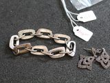 deux bijoux posés sur une table, à côté d'un sachet de thé