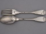 two forks and a spoon sitting on a table