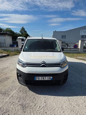 la camionnette blanche est garée dans un parking près d'un bâtiment