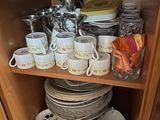 de nombreuses tasses et soucoupes posées sur une étagère dans un vaisselier