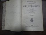 un livre ouvert posé sur une table, à côté d'une table en bois