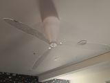 un ventilateur de plafond dans une pièce dont l'un des murs est tapissé