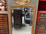 un miroir posé par terre à côté d'une commode