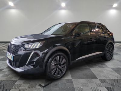 un 4x4 noir garé sur un sol en damier dans un garage