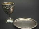 une coupe en argent et une assiette en argent sur fond noir
