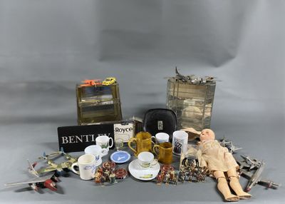 a doll sitting next to a pile of assorted items