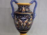 un vase bleu et jaune posé sur une surface blanche