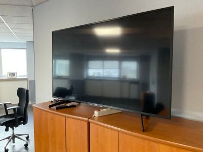 un grand téléviseur à écran plat posé sur un meuble dans une pièce
