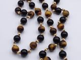 a close up of a tiger ' s eye beaded necklace on a white surface