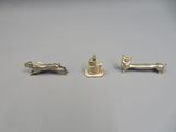 three silver figurines of a dog, a cat and a dog