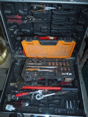 une caisse d'outils avec des outils à l'intérieur, posée sur le sol