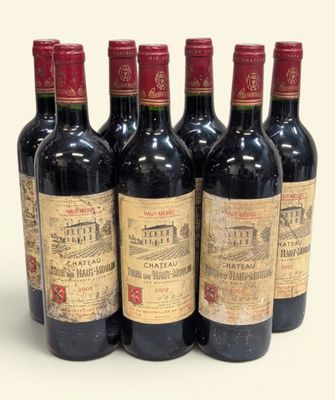 six bouteilles de vin sont alignées sur une surface blanche