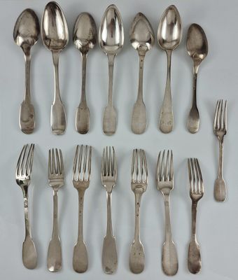 un grand nombre de cuillères et de fourchettes en argent disposées sur une table