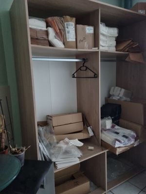 un placard sur lequel sont posés de nombreux cartons et vêtements