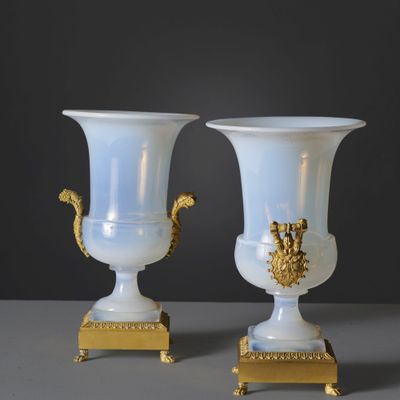 two white vases sitting on top of a table next to each other