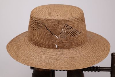 un chapeau de paille posé sur un support en bois