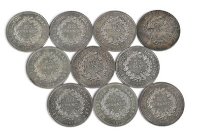 six types différents de pièces d'argent sur une surface blanche