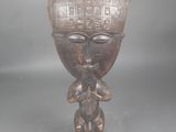 une vieille statue en bois d'un homme avec un chapeau sur la tête