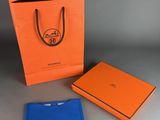 an orange and blue gift bag sitting next to an orange and blue gift bag