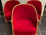 pair of red chairs with gold trim and wood legs