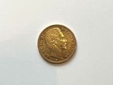 a close up of a gold coin on a white surface