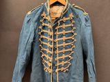 une vieille veste militaire bleue accrochée à un crochet fixé au mur