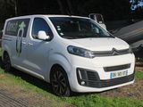 une petite camionnette blanche garée sur l'herbe, à côté d'un bateau