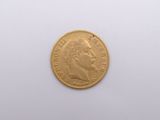 a close up of a gold coin on a white surface