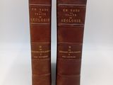 deux vieux livres reliés en cuir posés l'un sur l'autre sur une surface blanche