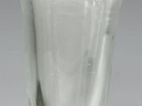 un vase en verre à bord vert posé sur une table